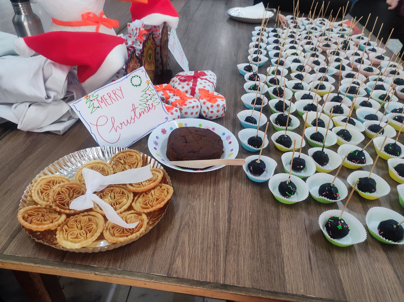 Table with festive snacks and a 'Merry Christmas' sign