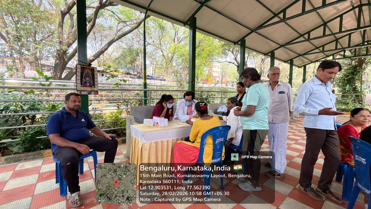 Dental staff consulting with patients at a table under a shelter